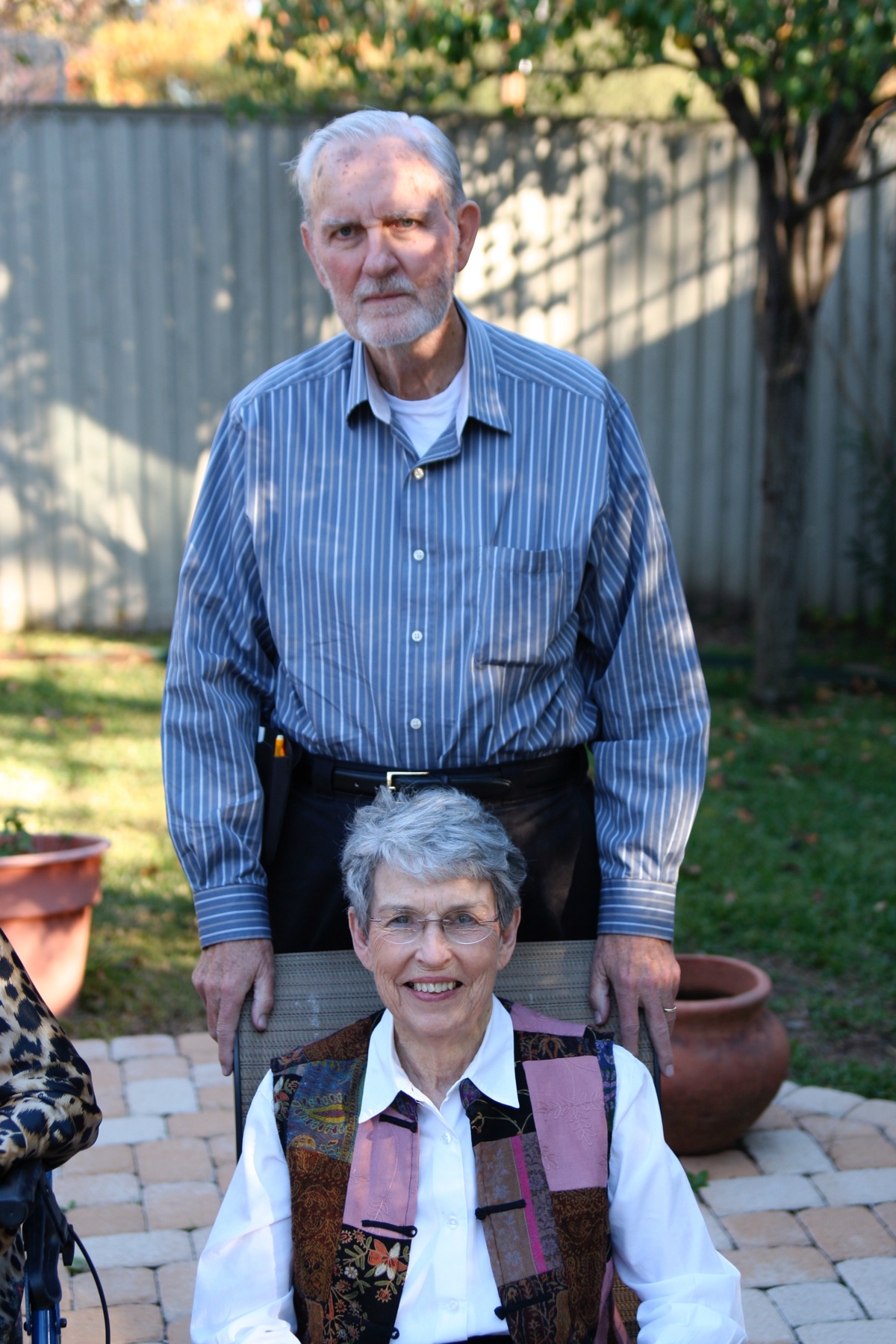 Marye and Franklyn in the backyard, Marye in a patchwork vest.